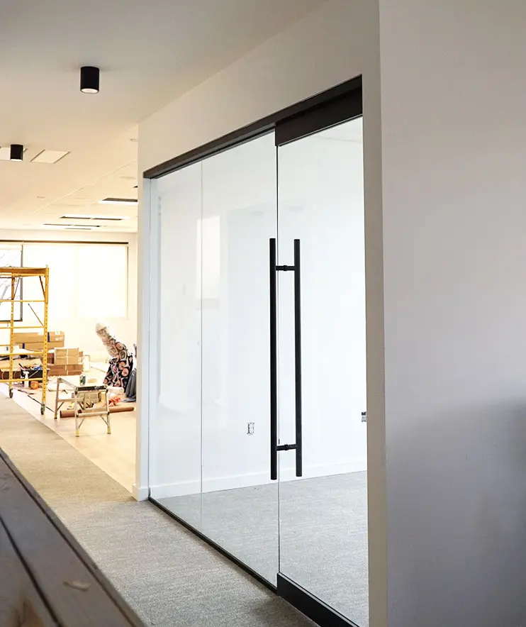 The office at Lenius Orthodontics in Overland Park, KS features glass walls, ceiling lights, and unpacked furniture with boxes.