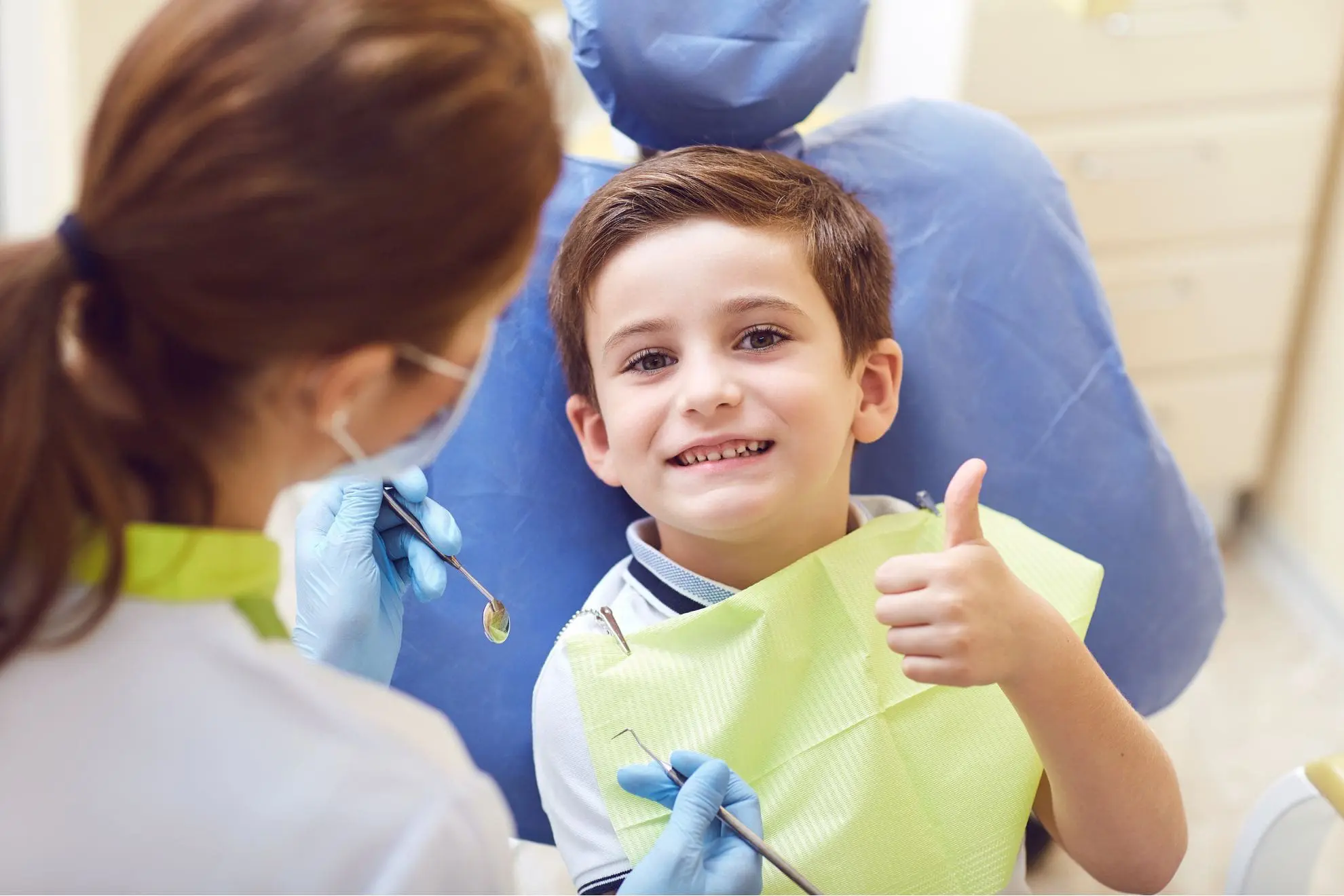 A young boy in a dental chair gives a thumbs up represent trusted myofunctional therapy for tongue thrust at Lenius Orthodontics in Overland Park, KS.