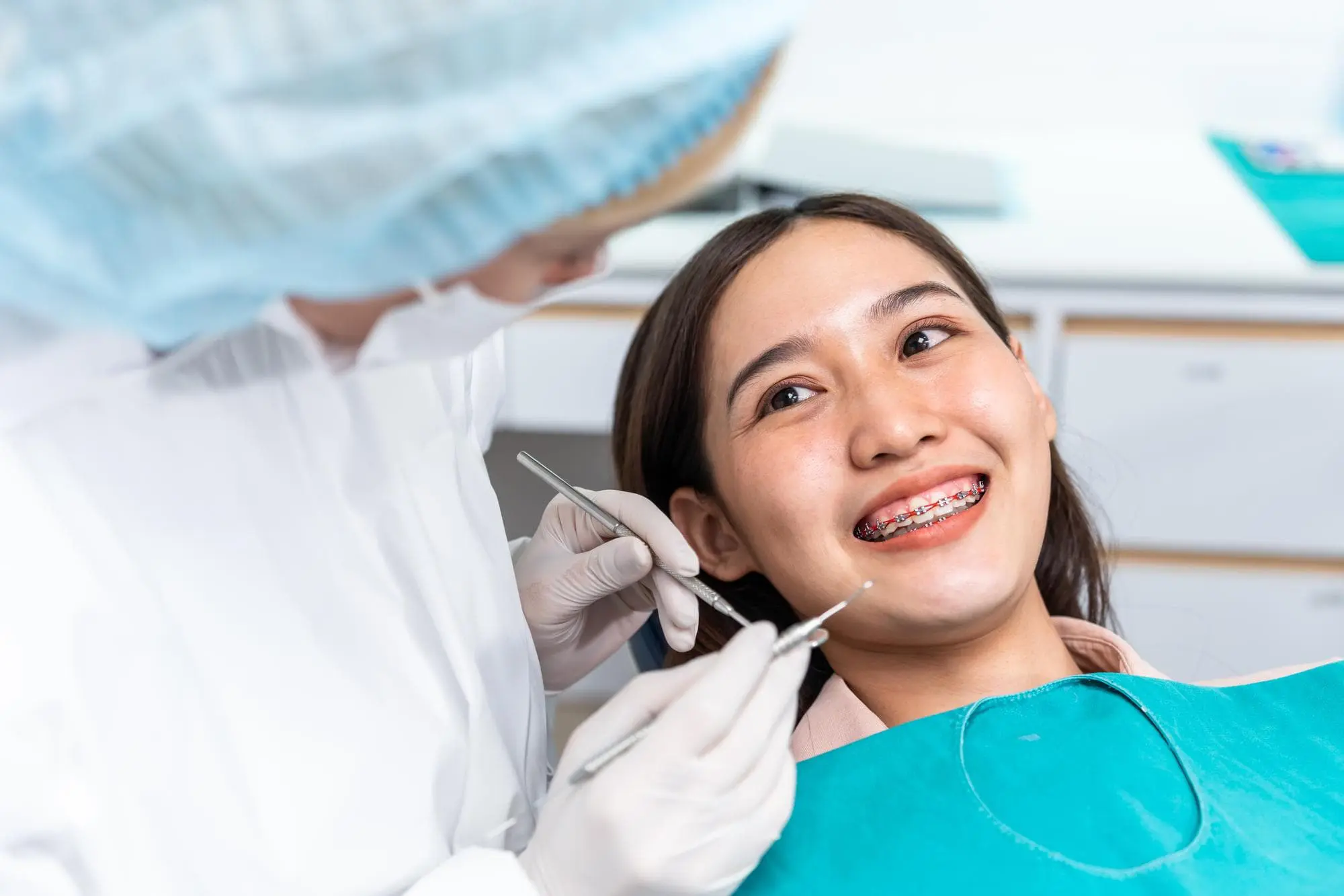 A smiling young woman with braces has a dental checkup represent flexible braces payment plan at Lenius Orthodontics in Overland Park, KS.