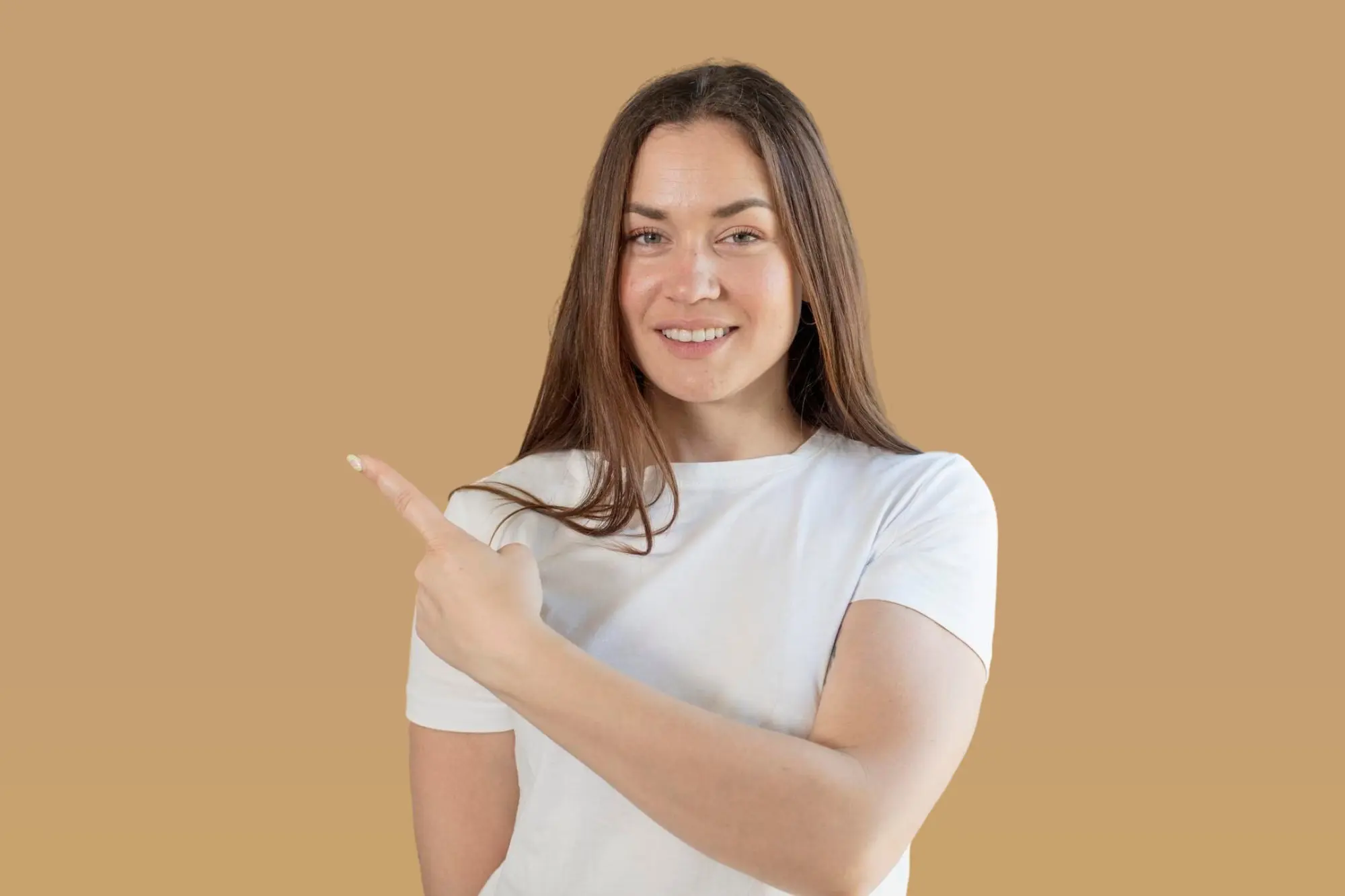 Smiling woman with long brown hair and Overbite in a white t-shirt points left; Lenius Orthodontics in Overland Park, KS.