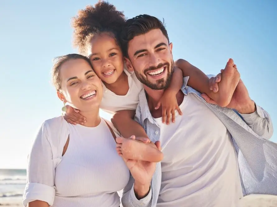 Enjoying a sunny day near the beach, three people smile together, representing trusted orthodontic appliances at Lenius Orthodontics in Overland Park, KS.