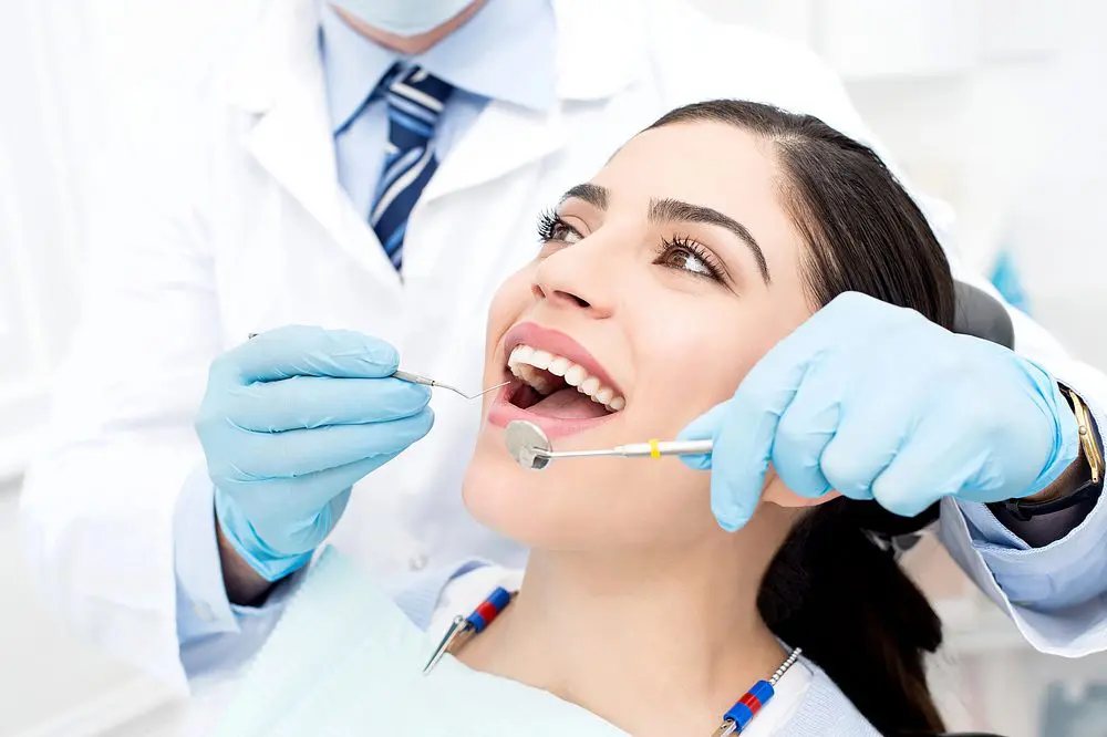 A woman smiling while being examined after being explained about how to fix overbite in overland park, KS