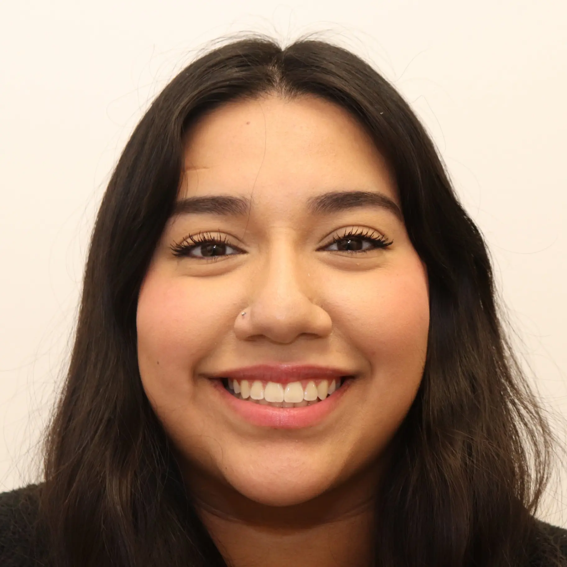 Smiling young woman with long dark hair representing after dental care with braces at Lenius Orthodontics in Overland Park, KS.
