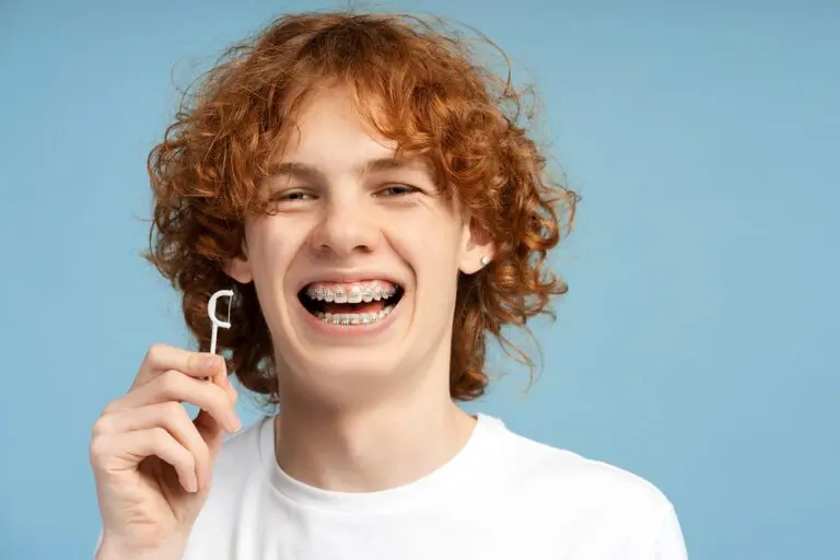 closeup image smiling teenager curly red hair metal braces - How to Floss with Braces in Overland Park, KS